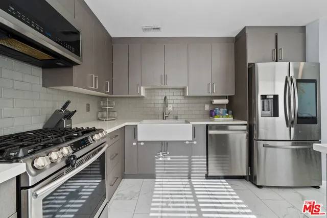 a kitchen with a stove a refrigerator and cabinets