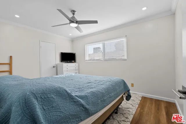a bedroom with a large bed and a flat tv screen