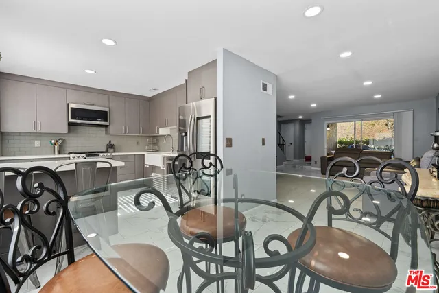 a kitchen with granite countertop a table chairs stove and microwave