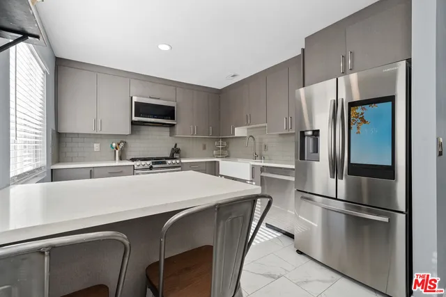 a kitchen with stainless steel appliances a refrigerator stove microwave and sink