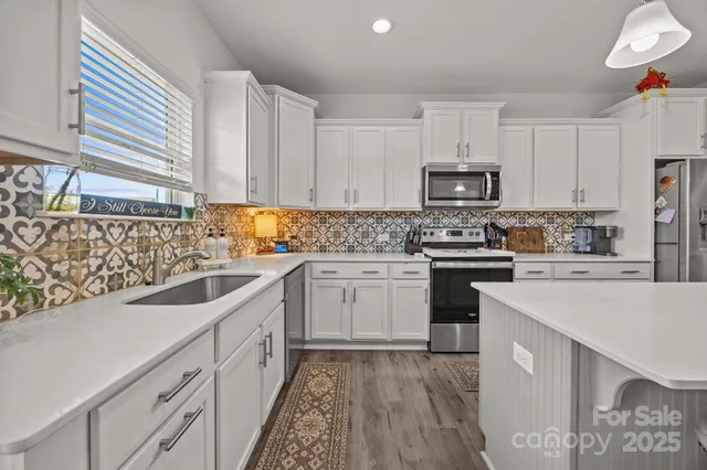 a kitchen with granite countertop a sink stainless steel appliances and cabinets