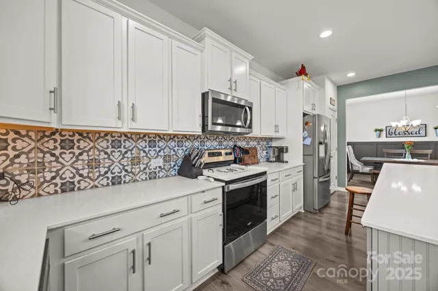 a kitchen with granite countertop a sink stainless steel appliances and cabinets