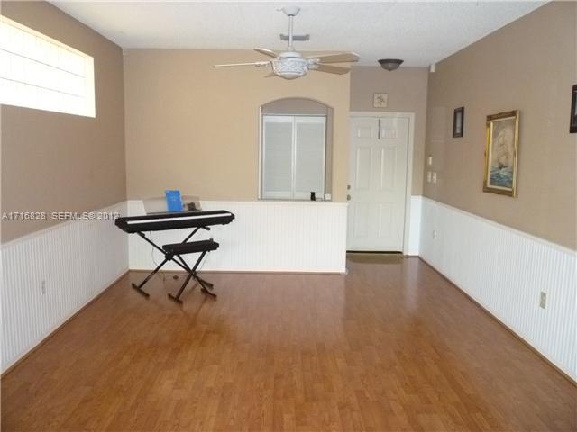 4070 Tree Top Road Cooper City, FL 33026 - Photo 2 of 12 a view of an empty room with a window and wooden floor