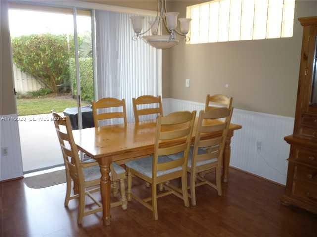 4070 Tree Top Road Cooper City, FL 33026 - Photo 4 of 12 a view of a dining room with furniture wooden floor and a chandelier