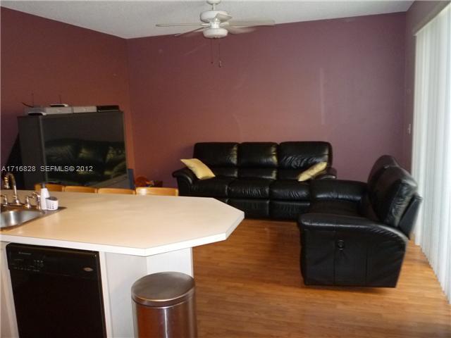 4070 Tree Top Road Cooper City, FL 33026 - Photo 5 of 12 a living room with furniture a flat screen tv and kitchen view