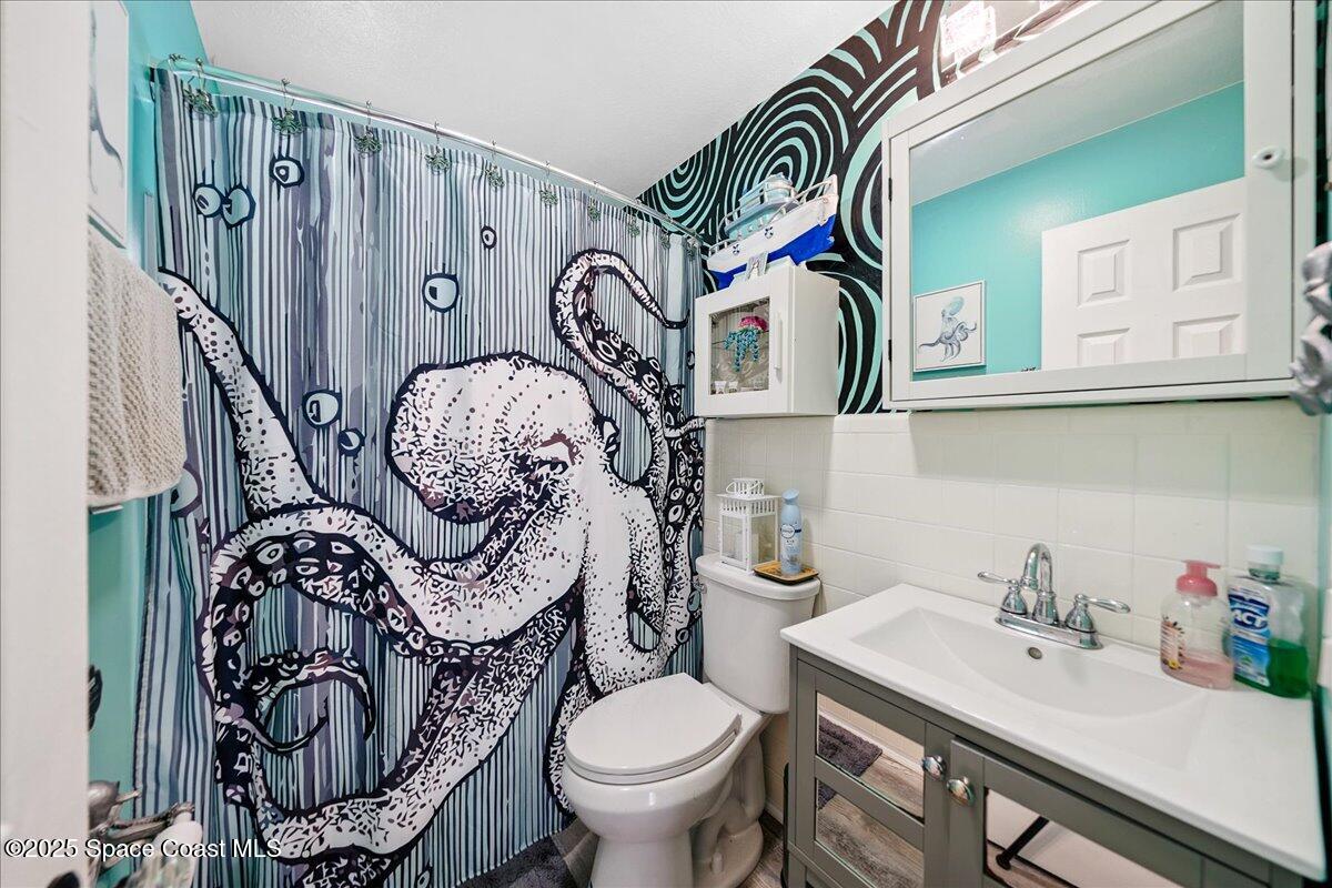 1405 Fiddler Avenue Merritt Island, FL 32952 - Photo 22 of 43 a bathroom with a sink mirror vanity and toilet