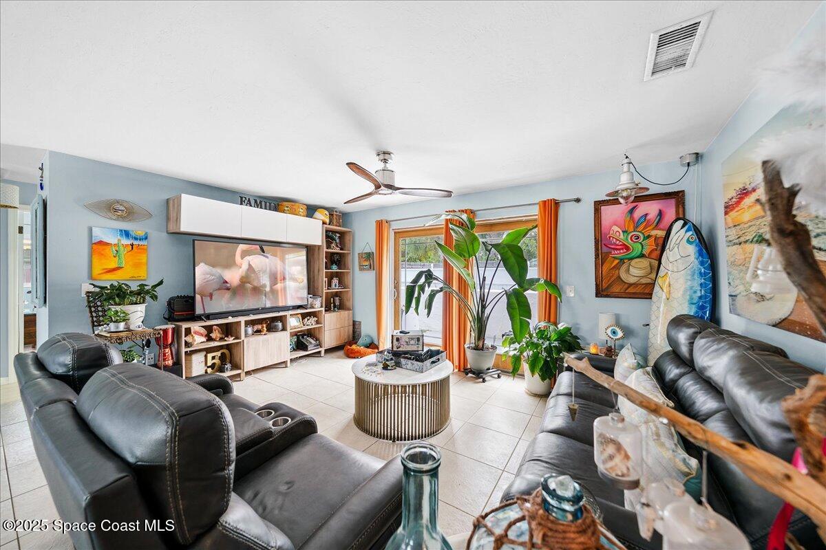 1405 Fiddler Avenue Merritt Island, FL 32952 - Photo 7 of 43 a living room with furniture a flat screen tv and a large window