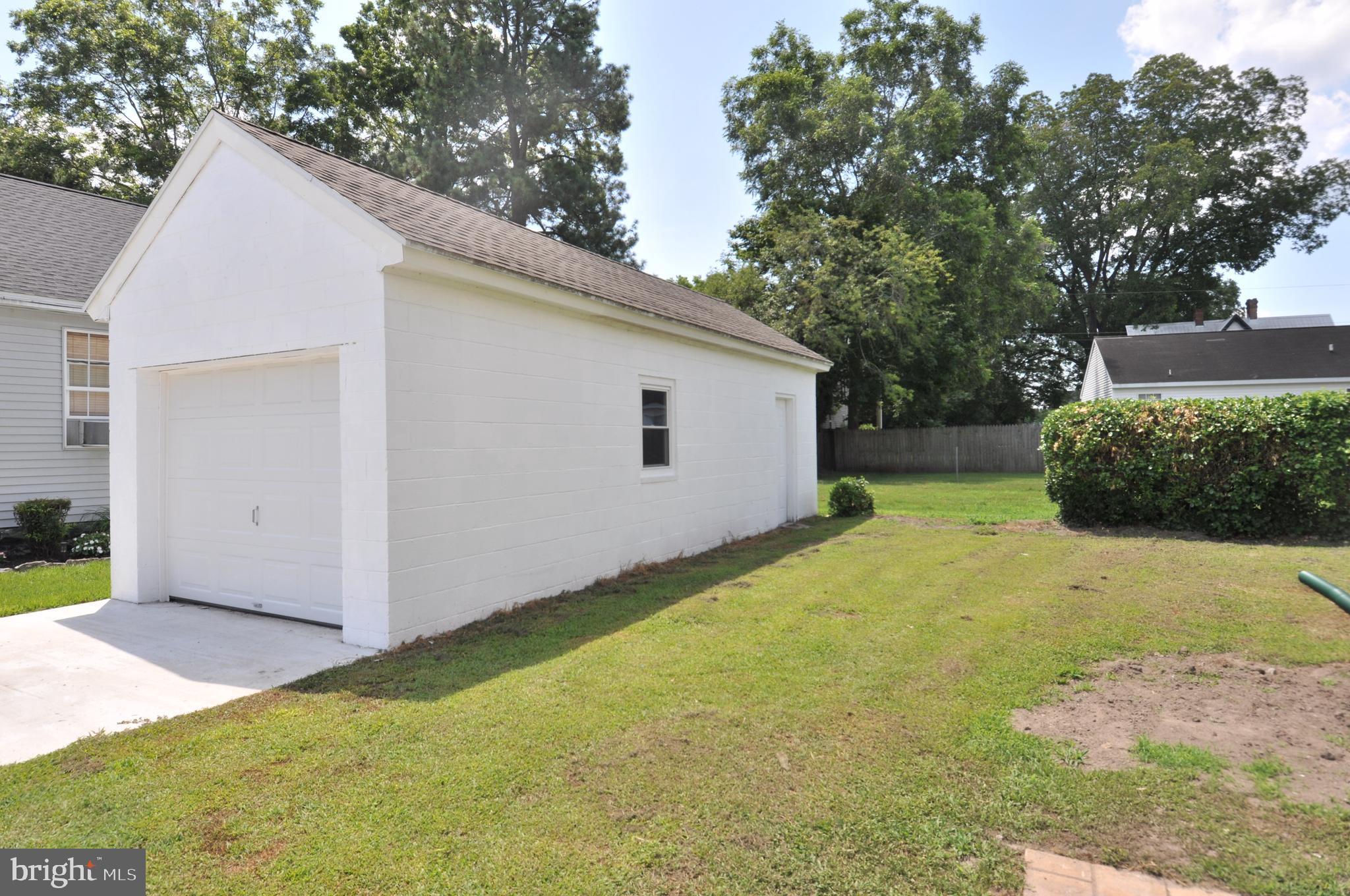 601 4th Street Pocomoke City, MD 21851 - Photo 8 of 35 a view of a white house with a yard and a large tree