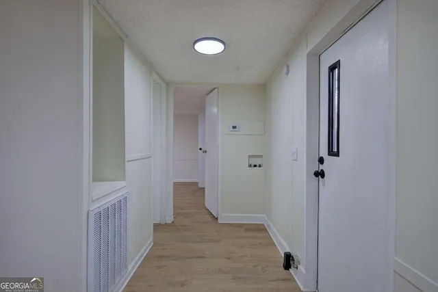 a view of a hallway with wooden floor and closet area