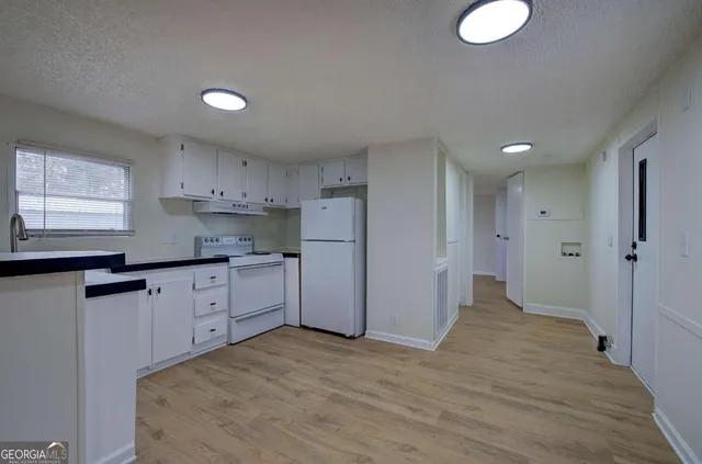 a kitchen with granite countertop cabinets and refrigerator