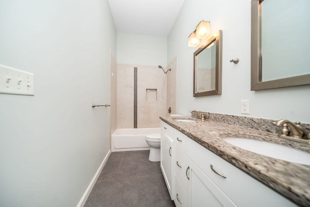 81 Broadway, Unit 1 Chelsea, MA 02150 - Photo 12 of 29 a spacious bathroom with a granite countertop sink and a mirror