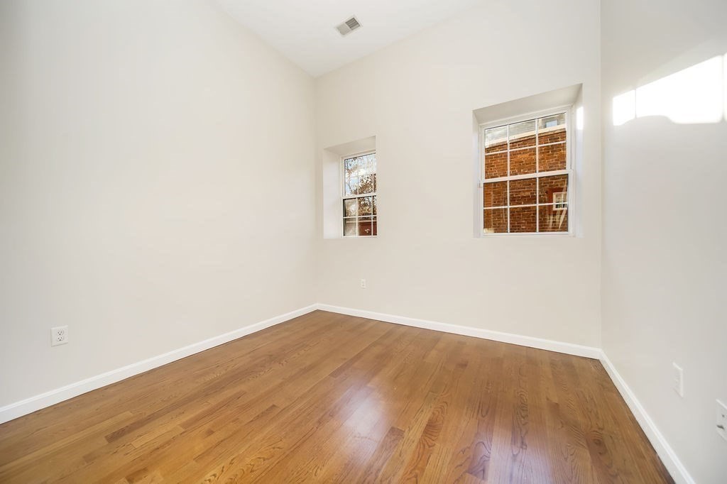 81 Broadway, Unit 1 Chelsea, MA 02150 - Photo 19 of 29 an empty room with wooden floor and windows