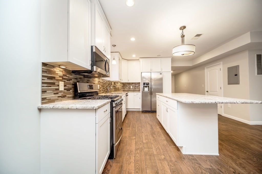 81 Broadway, Unit 1 Chelsea, MA 02150 - Photo 7 of 29 a kitchen with stainless steel appliances a sink stove and refrigerator