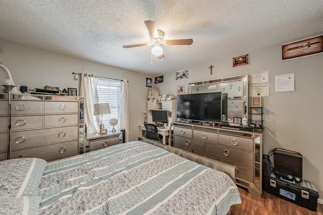 a bedroom with a large bed and a flat tv screen on dresser