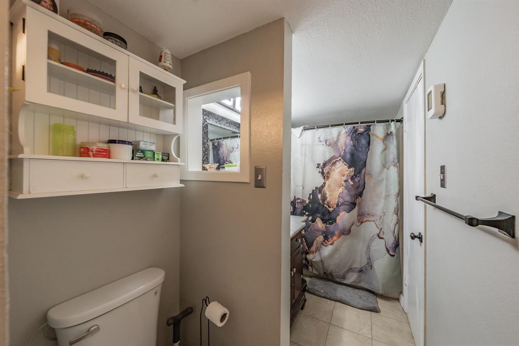 623 Ridgeline Drive Hurst, TX 76053 - Photo 22 of 29 a bathroom with a toilet and a shower curtain