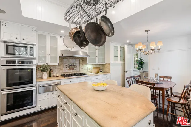 a kitchen with a stove a kitchen island a dining table and chairs