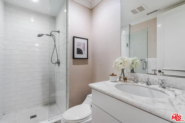 a bathroom with a granite countertop sink toilet and shower
