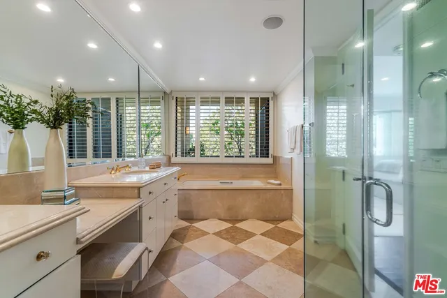 a bathroom with a large tub sink shower and mirror