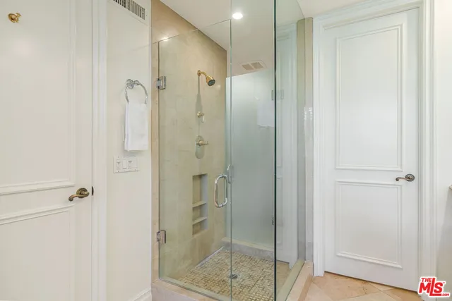a bathroom with a shower and a glass door