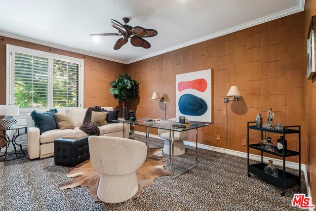 a living room with couches a rug and a potted plant