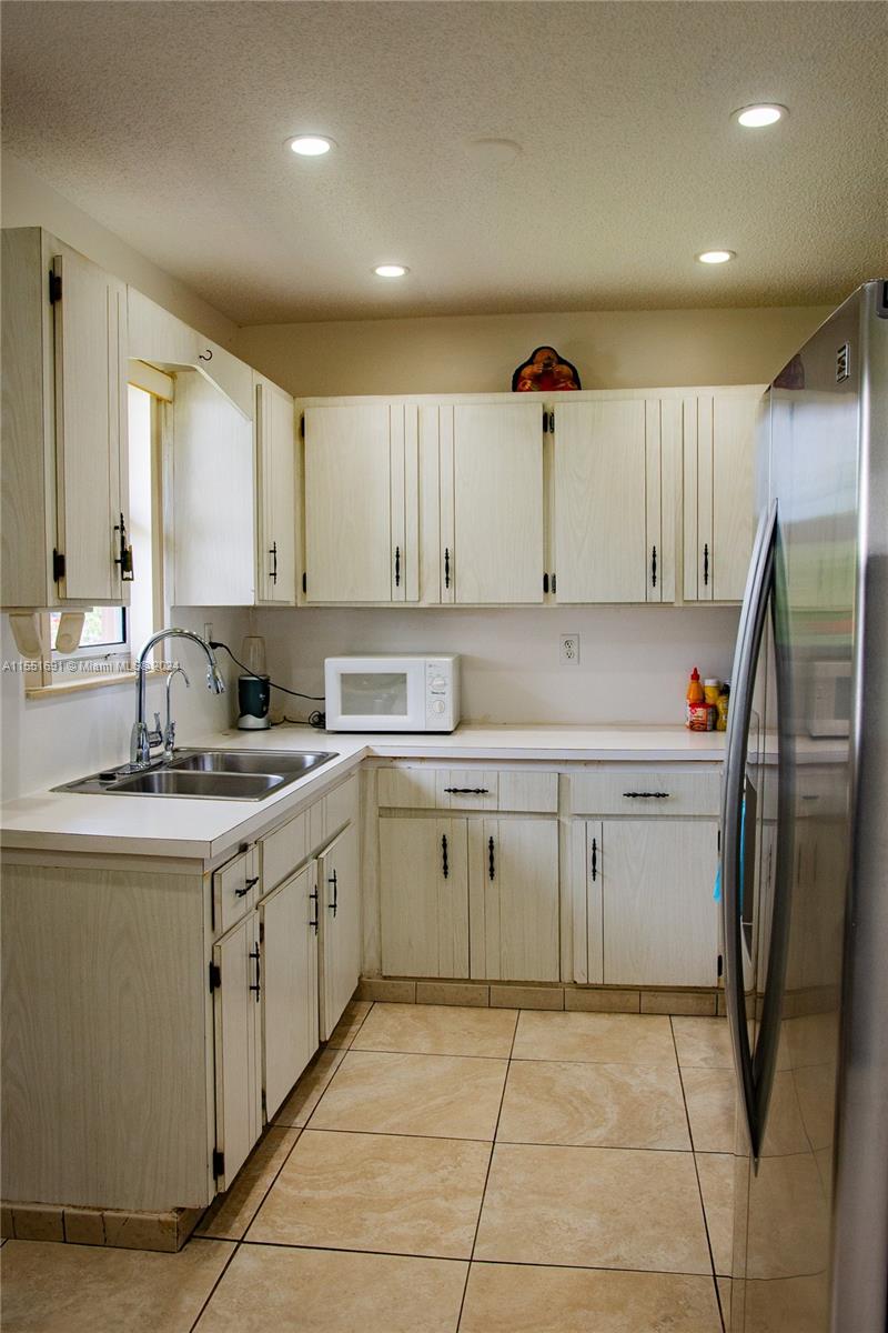 6005 Southwest 22nd Street Miami, FL 33155 - Photo 14 of 36 a kitchen with stainless steel appliances granite countertop a sink counter space cabinets and a large window
