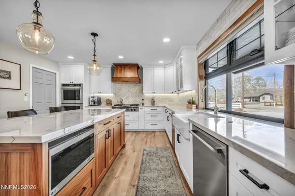 a kitchen with granite countertop a sink stove and wooden floor