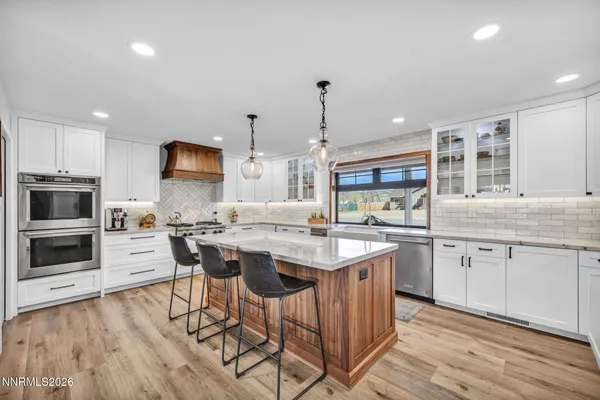 a kitchen with stainless steel appliances granite countertop white cabinets and a stove