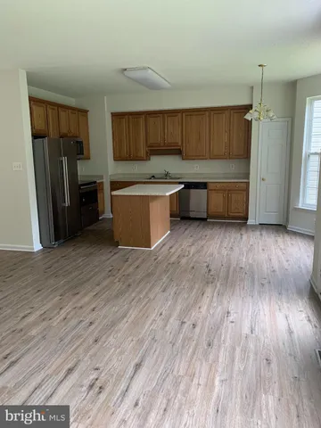a view of a kitchen with wooden floor and electronic appliances