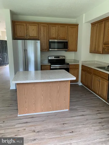 a kitchen with granite countertop a refrigerator and a sink