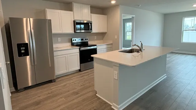 a kitchen with stainless steel appliances a refrigerator stove microwave and sink