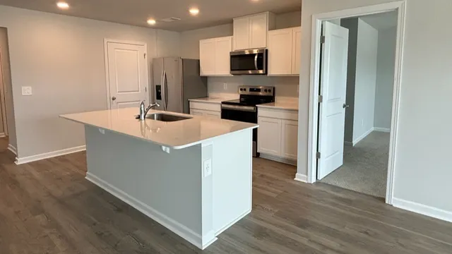 a kitchen with kitchen island a sink stainless steel appliances and cabinets