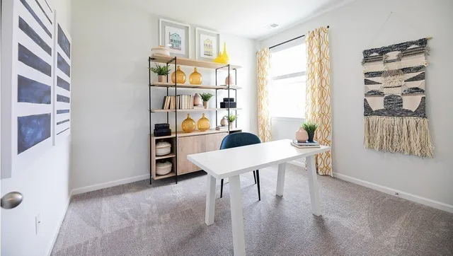 a view of a workspace with furniture and a window