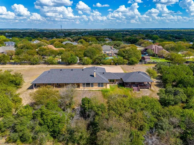 an aerial view of house with yard ocean and mountain view