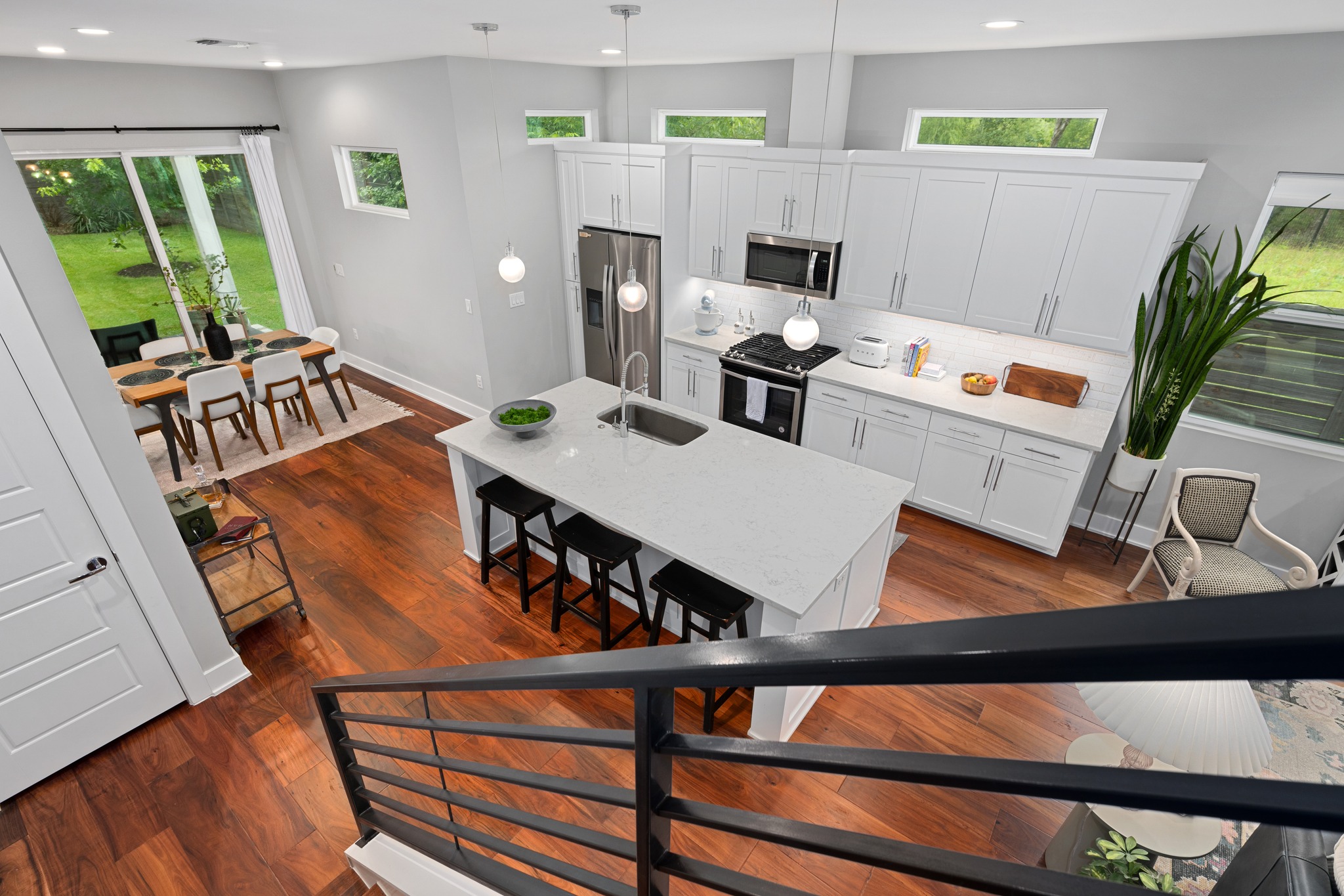 1103 Saucedo Street, Unit 1 Austin, TX 78721 - Photo 27 of 40 An open-concept living space features warm hardwood floors and a modern kitchen island with seating.