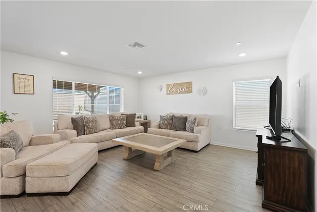 a living room with furniture flat screen tv and wooden floor