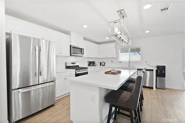 a kitchen with a refrigerator a dining table and chairs