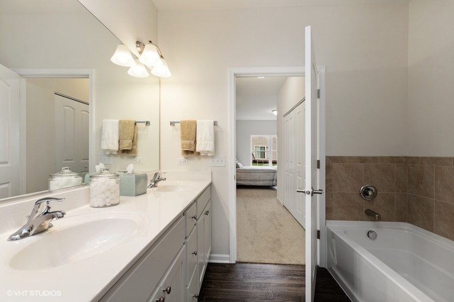 1004 Lexington Street McHenry, IL 60050 - Photo 13 of 20 a bathroom with a tub sink double vanity and mirror