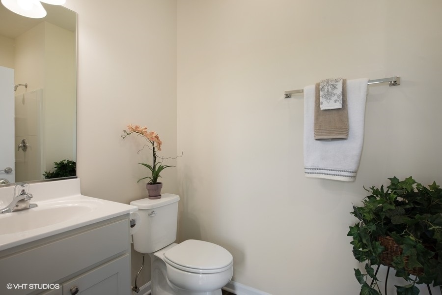 1004 Lexington Street McHenry, IL 60050 - Photo 14 of 20 a bathroom with a sink mirror and toilet
