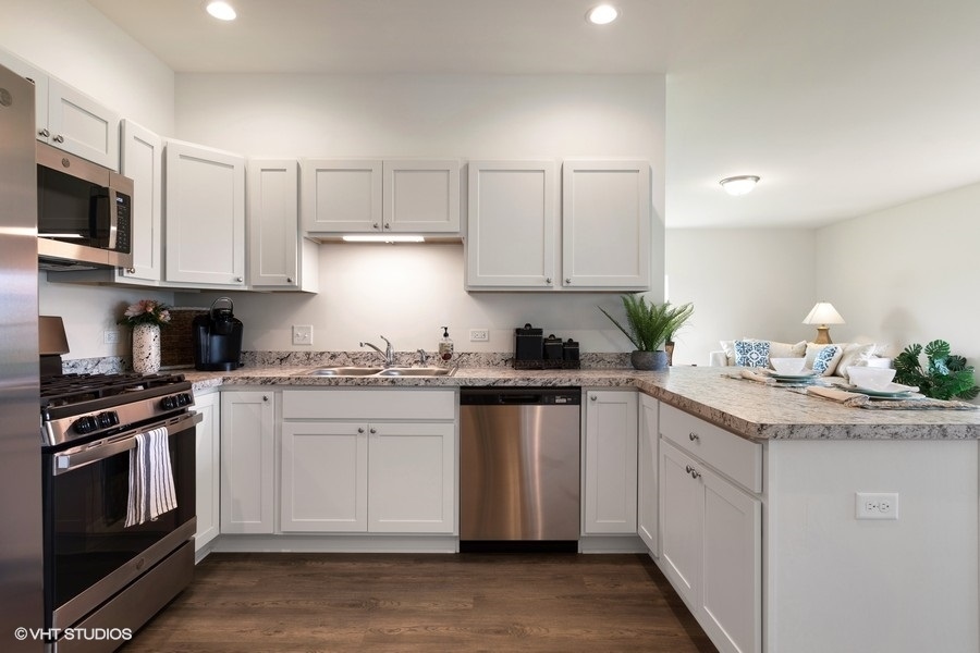 1004 Lexington Street McHenry, IL 60050 - Photo 9 of 20 a kitchen with stainless steel appliances granite countertop a stove a sink and a microwave
