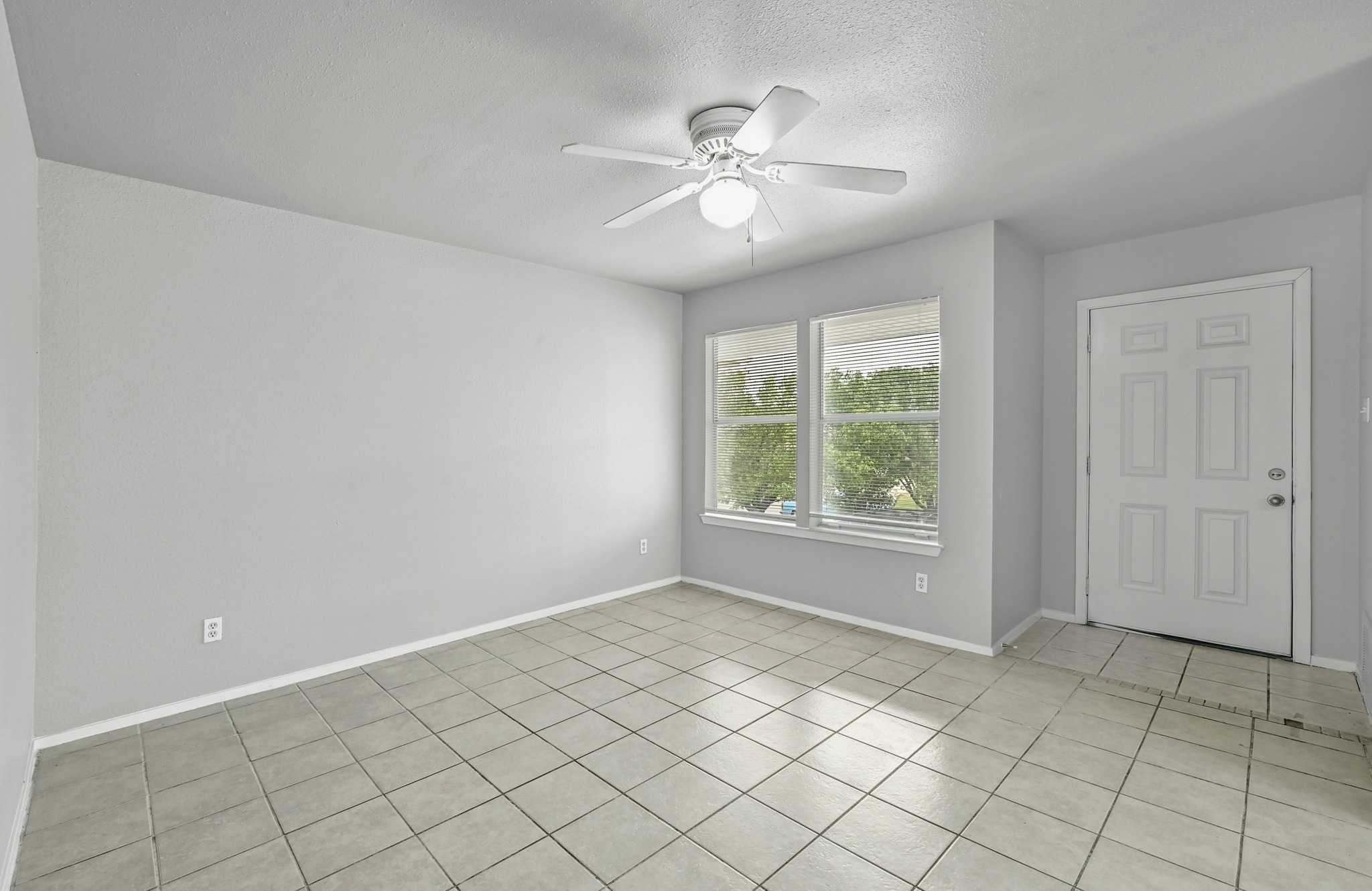 2212 Katy Lane Georgetown, TX 78626 - Photo 5 of 27 The property features a spacious room with light gray walls, tile flooring, and a ceiling fan with an integrated light fixture