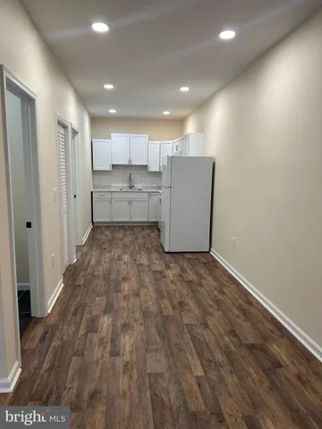 a view of a kitchen with a sink and wooden floor