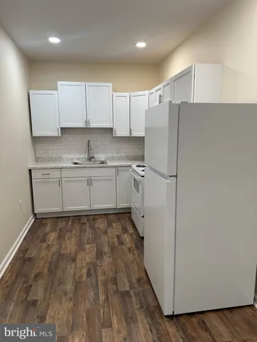 a kitchen with a refrigerator a sink and cabinets