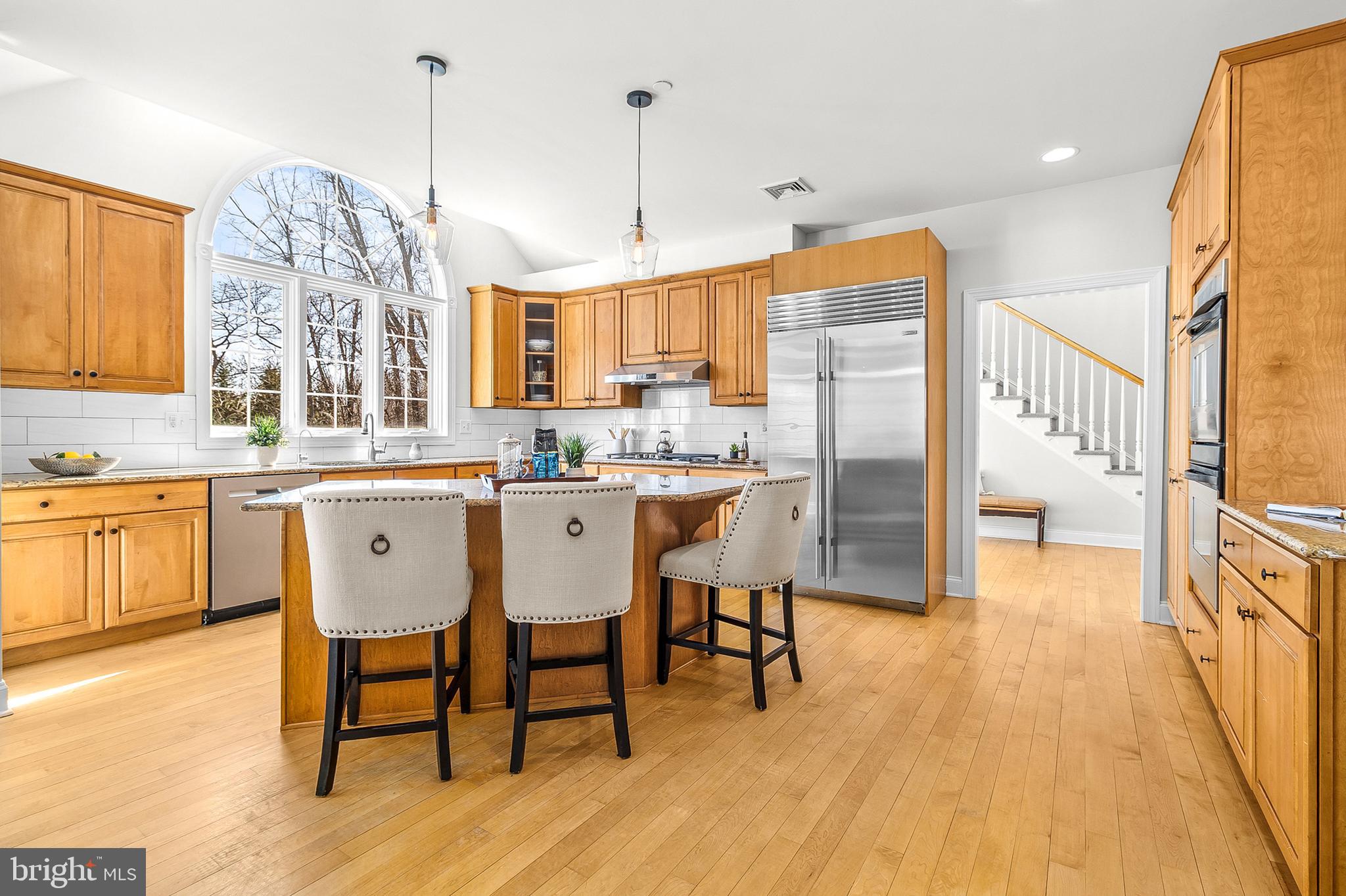 4 Greystone Circle Newtown Square, PA 19073 - Photo 11 of 51 a kitchen with stainless steel appliances a dining table chairs a sink and dishwasher a refrigerator with wooden floor