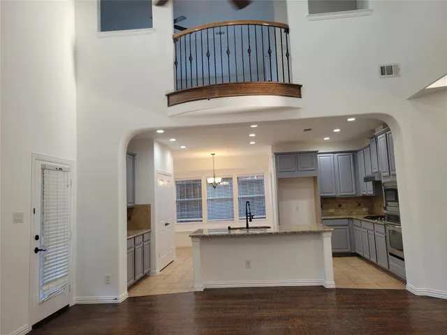 a kitchen with stainless steel appliances granite countertop a refrigerator a stove and a sink