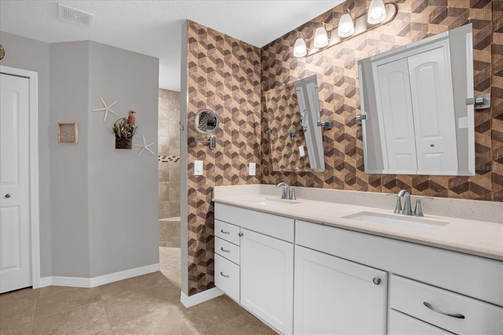 3782 Arlington Ridge Boulevard Leesburg, FL 34748 - Photo 15 of 52 a bathroom with a double vanity sink and mirror