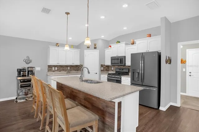 a kitchen with stainless steel appliances kitchen island granite countertop a kitchen island a stove and a cabinets