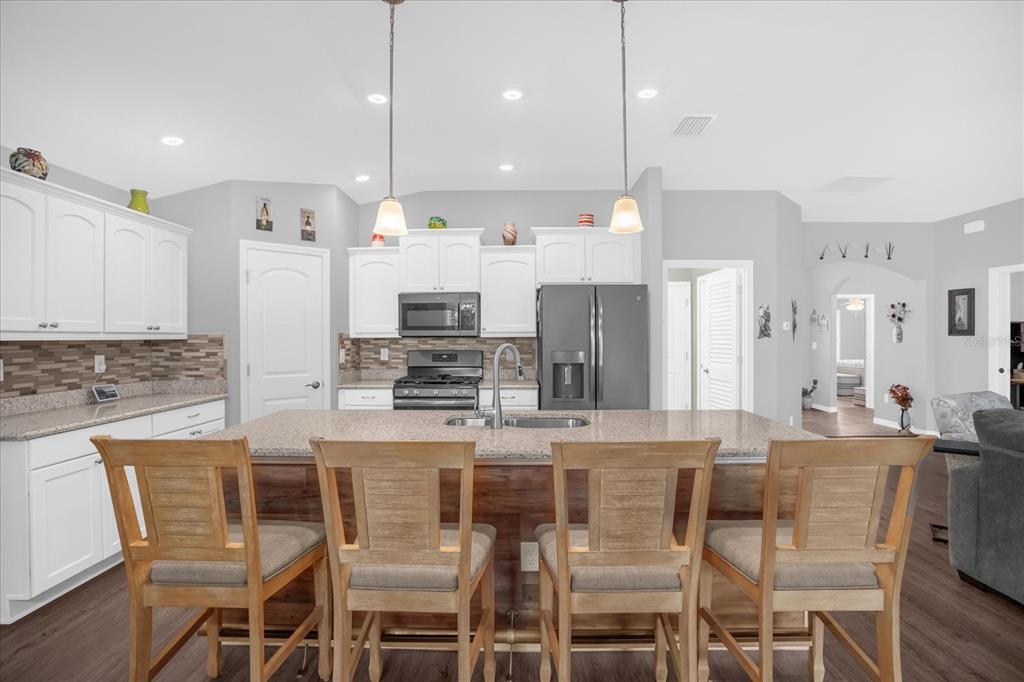 3782 Arlington Ridge Boulevard Leesburg, FL 34748 - Photo 10 of 52 a kitchen with stainless steel appliances kitchen island granite countertop a kitchen island a stove and a cabinets