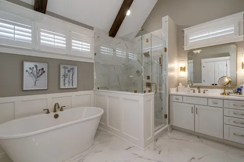 a spacious bathroom with a bathtub sink and mirror