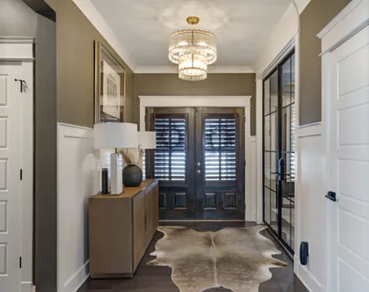 a view of hall way with mirror and furniture