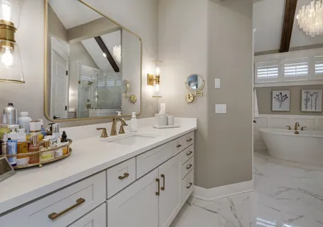 a bathroom with a double vanity sink mirror and bathtub